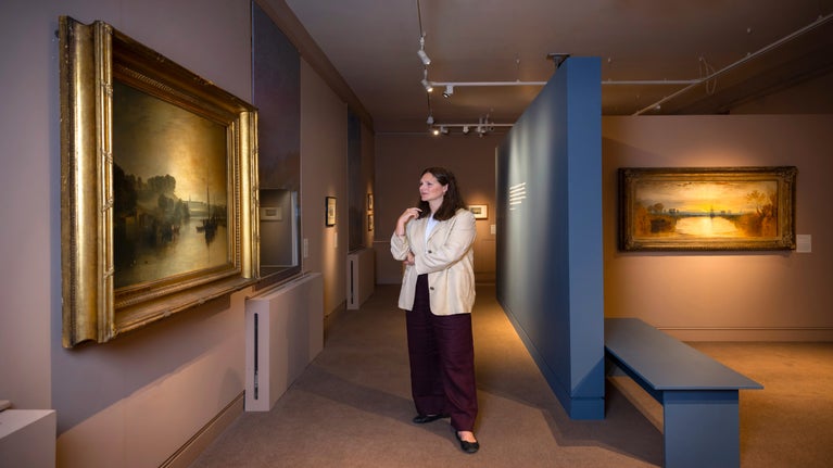 Curator Emily Knight views one of the paintings in the Turner exhibition